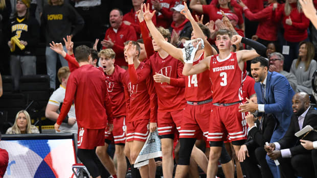 The bench for Wisconsin men's basketball gets fired up after a made three.